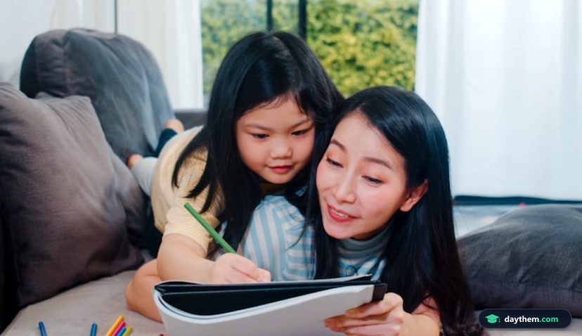 Người phụ nữ trung niên đang hướng dẫn con gái học và vẽ tại nhà
