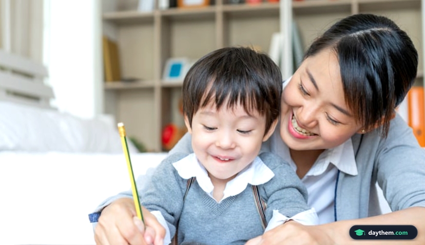 Young mother teaching her son write on paper with love