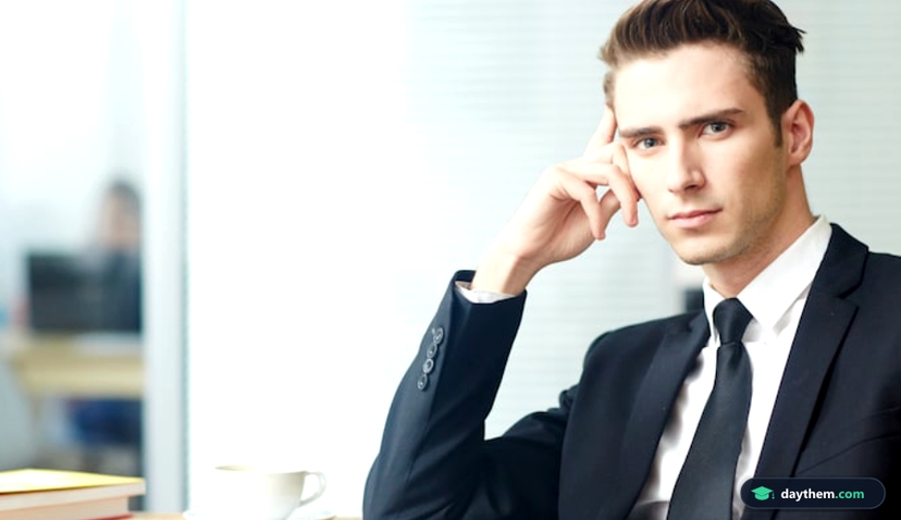 Nhân viên văn phòng mặc áo sơ mi, chống tay lên cằm và suy ngẫm trầm tư trong không gian làm việc.