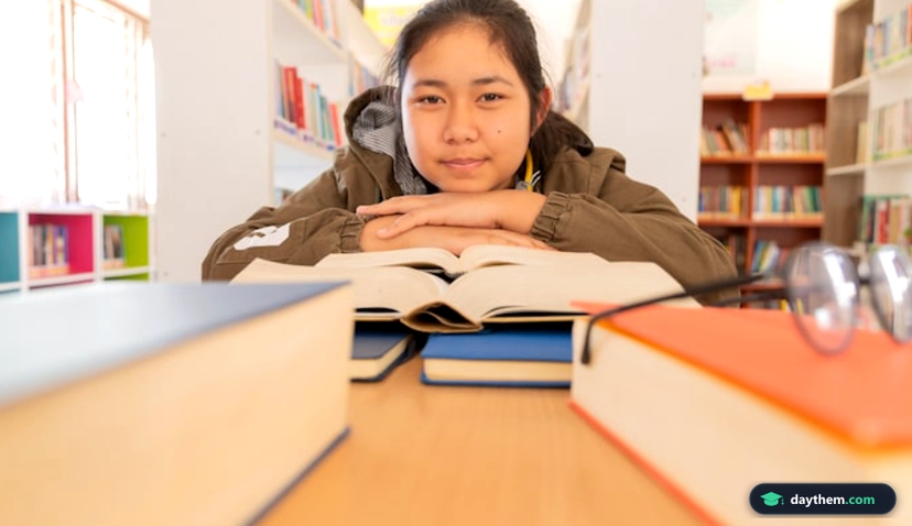 In the library - Young girl student with books working in a high school library.