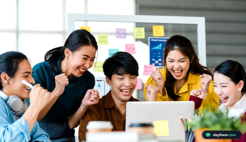 Nhóm người trẻ phong cách trẻ trung đang thảo luận công việc và đập tay ăn mừng trong văn phòng.